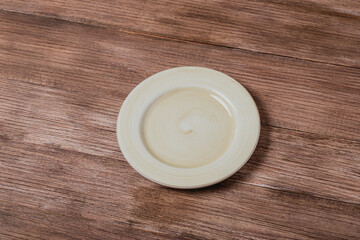 Empty ceramic plate mock up over rustic wooden table
