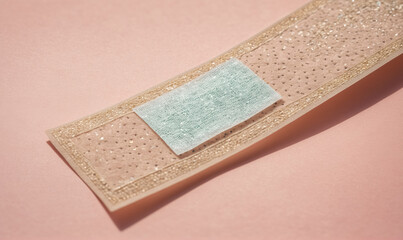 A light blue patch is attached to a brown, textured adhesive bandage