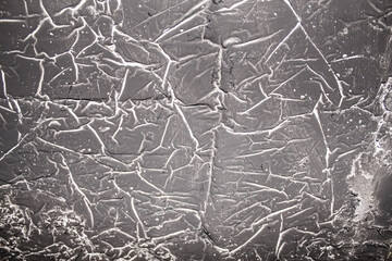 Obraz premium Close-up of textured gray wall with intricate crack patterns revealing an aged, weathered surface during daylight