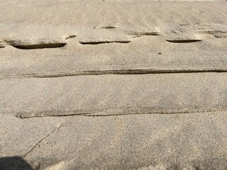 Uneven tracks in the sand with shadows