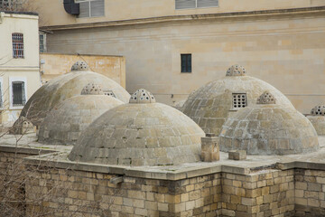 View of neighborhood from the roof. Ancient bath house in Baku, Azerbaijan . Amazing domes with convex glasses on scenic roof .