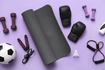 Set of sports equipment on lilac background, top view