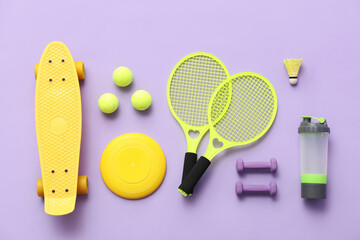 Set of sports equipment on lilac background, top view