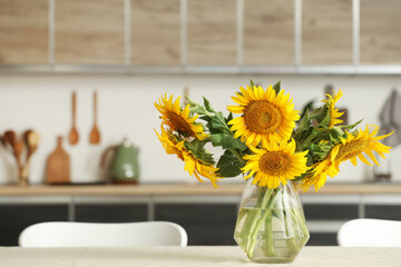 Vase with sunflowers on dining table in kitchen