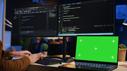 Green screen laptop in home office used by programmer for developing software applications. Mockup...