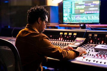 African american record composer creating new music for an album, editing and mixing tunes on...