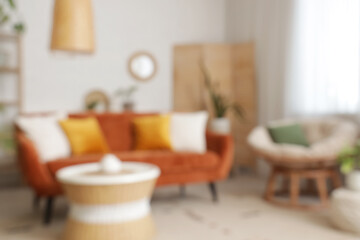 Blurred view of living room with red sofa, armchair and plants