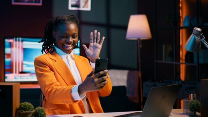 African american student attending online career course in videocall, using smartphone to meet remotely with classmates and professor. Pupil discussing about assignments with tutor. Camera A.