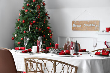 Dining table with Christmas setting and burning candles in room