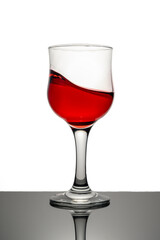 Red wine in glass in front of white background