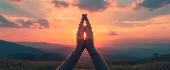 Silhouette of hands clasped in prayer at sunset.
