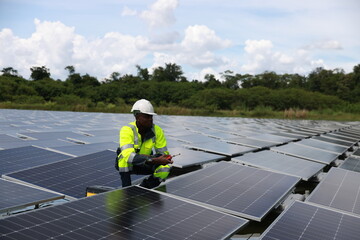 The black male Solar energy systems engineer performs analysis of solar panels  at the solar farm