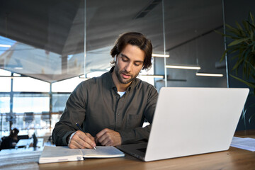 Busy professional young business man manager worker wearing earbuds working in office elearning or...