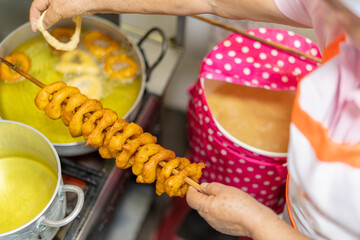 Street vendor preparing picarones, peruvian sweet potato and squash doughnuts