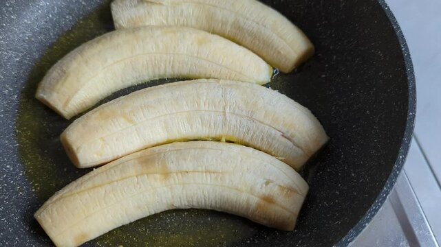 Close-up of banana in teflon pan, baking banana, cooking, snack, 4K.