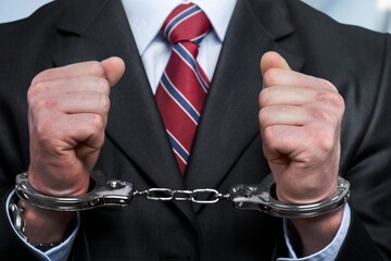 Businessman person hands in handcuffs arrested