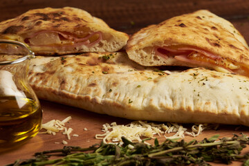 Calzone, traditional Italian preparation accompanied by spices and red wine