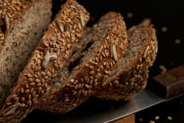 Artisanal bread made and baked at home with multigrain seeds on a dark background, a healthy product to enjoy with the family.