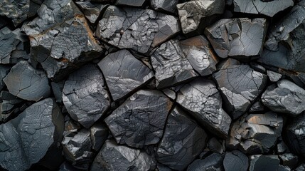 Close-up of dark grey, cracked, and weathered rocks forming a textured background.