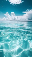 Fototapeta premium Calm Turquoise Ocean Waters with White Clouds in a Blue Sky