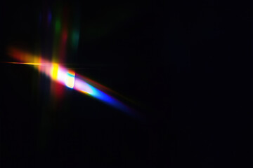 Bright rainbow colored flare of light on black. Abstract background.