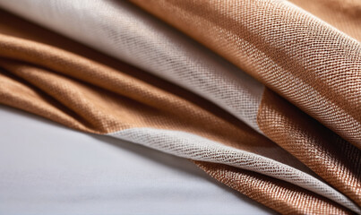 A close-up shot of brown and white striped fabric folded on a white surface