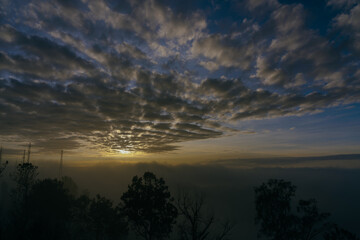 Obraz premium Dramatic stormy dark cloudy sky with fog. Sunset in the sky.