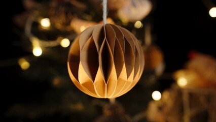 Warmly Lit Brown Paper Ornament, Hanging on a Christmas Tree with Twinkling Lights in the...