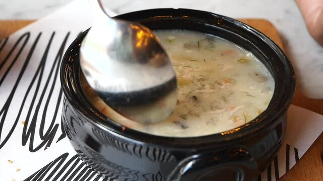 Enjoy a Delicious Bowl of Soup topped with Fresh Parsley in a Stylish Black Ceramic Bowl