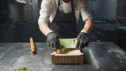 Chef Transforming The Green Dough Into Spaghetti