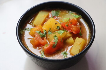 Tomato Batata Rassa Bhaji, tangy curry made with tomato, potato, cononut and spices, dish from Konkan Maharashtra, India, served with rice or flat bread