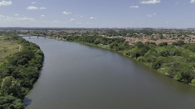 Drone flies backwards over Poti River toward the Meeting of the Rivers on sunny afternoon with Parna&iacute;ba River in Teresina, Piau&iacute;, Brazil