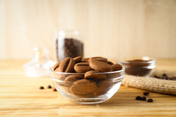 Cookies in the shape of coffee beans in transparent bowls