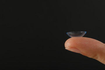 Close-up of a clear contact lens on a fingertip
