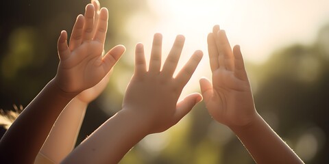 Closeup of children high-fiving, with a soft-focus background of a sunny park