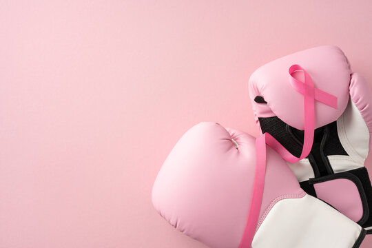 Pink boxing gloves with a pink ribbon highlight breast cancer awareness and strength against cancer - Powered by Adobe