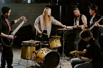 Wide shot of modern alternative rock band getting ready for rehearsal or performance