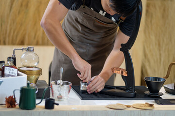 barista is preparing equipment for making coffee.