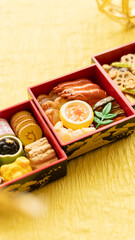 お節料理　日本のお正月　黄色背景　ミニチュア