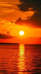 Fototapeta premium A sunset over the ocean with the sun setting in the distance