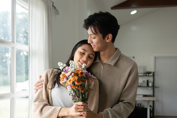Romantic Embrace Between Couple Holding Flower Bouquet
