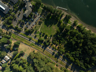 Fototapeta premium A park with a road running through it and a lake in the background