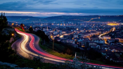 Obraz premium Nighttime view of a city with a winding road and glowing lights. AI.