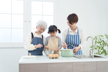 キッチンで料理をする三世代家族