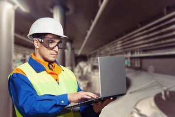 A confident engineer stands wearing a safety helmet