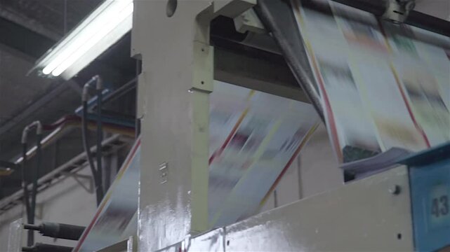 A busy book printing factory operates efficiently, with machines printing, binding, and packaging books through an automated process