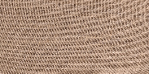 Close-up on raw, natural jute fabric, used in the making of handicrafts. backgrounds and textures. Closeup brown sack texture background