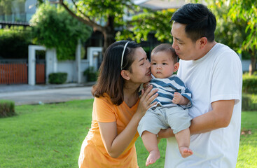 Parents with little child are having fun and resting in a park