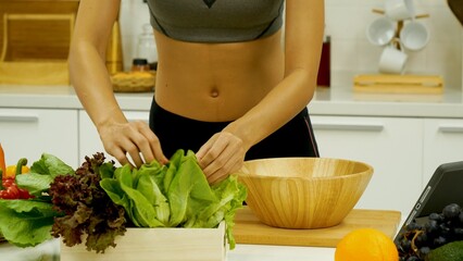 Close up Women hand prepare fruit vegetables vegan salad season oil salad dressing green oak red oak lettuce at home kitchen. Women hands cooking vegan healthy fresh fruit tomato pepper vegetables
