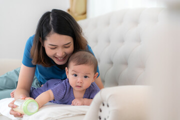 A mother lulls her little child to sleep on the sofa in the living room of the house